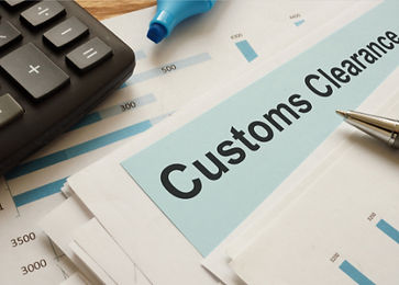 Customs clearance document beside a calculator and pen